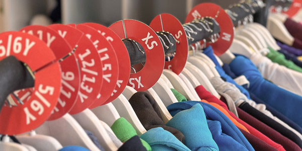 close-up van sweaters en hoodies in verschillende kleuren op een kledingrek